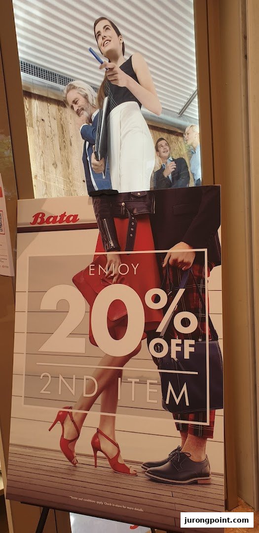 A Bata promotional standee advertising 'Enjoy 20% Off 2nd Item' with models wearing shoes.
