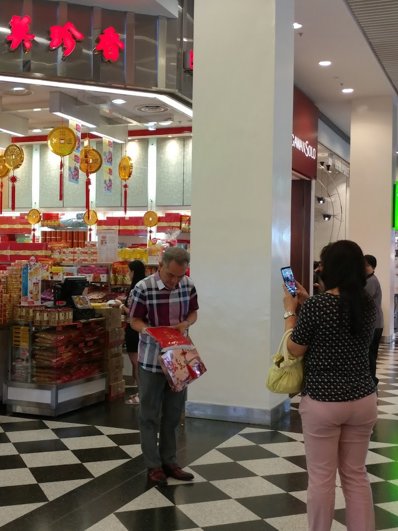 Customers browse products and festive decorations inside Bee Cheng Hiang, a traditional Asian snack shop.