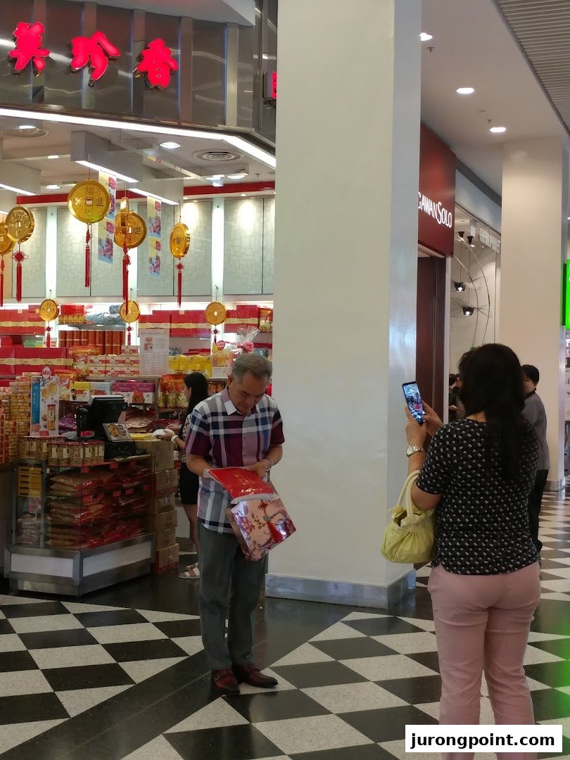 Customers browse products and festive decorations inside Bee Cheng Hiang, a traditional Asian snack shop.