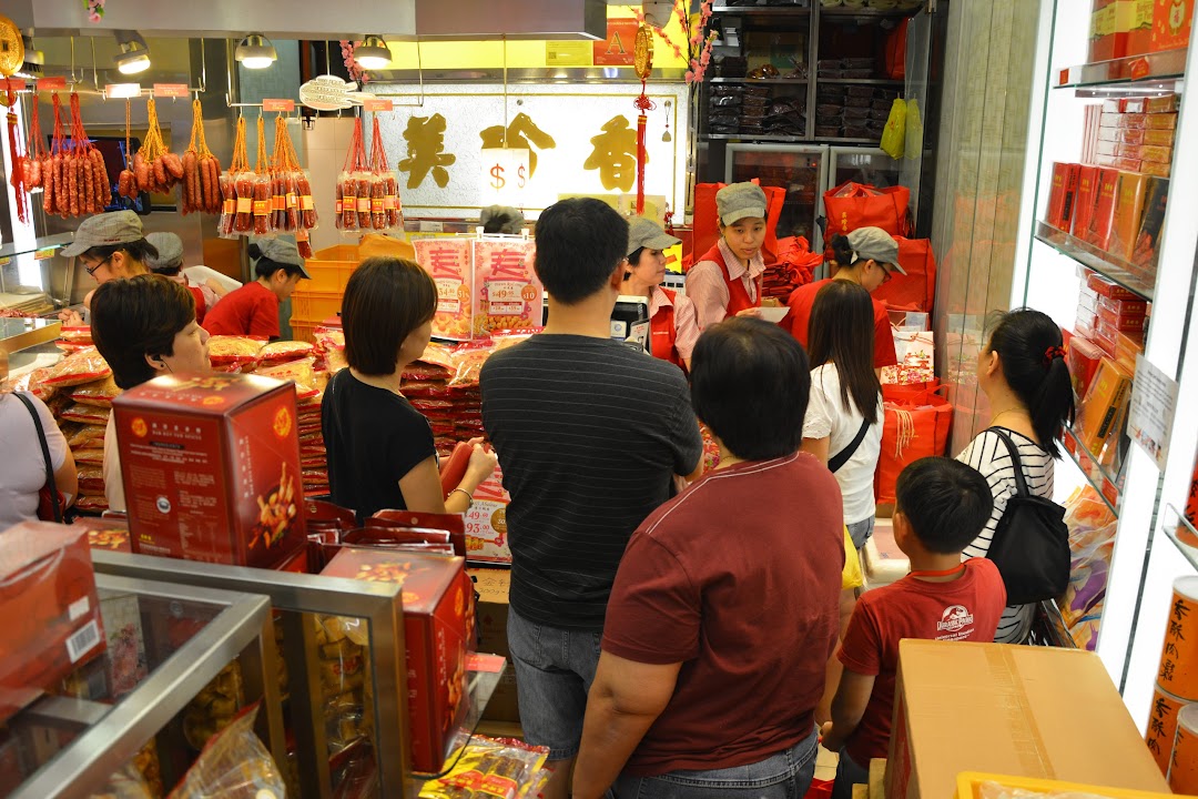 Customers browse and shop for traditional meat products and gift boxes inside a bustling Bee Cheng Hiang store.