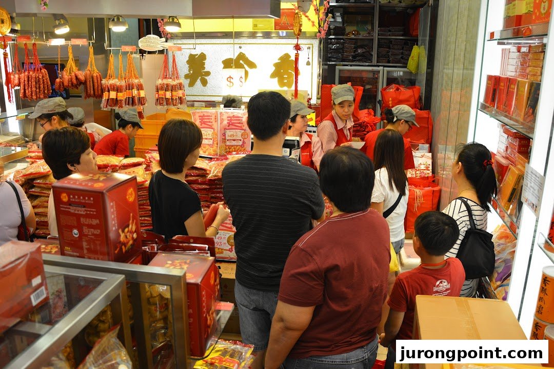 Customers browse and shop for traditional meat products and gift boxes inside a bustling Bee Cheng Hiang store.