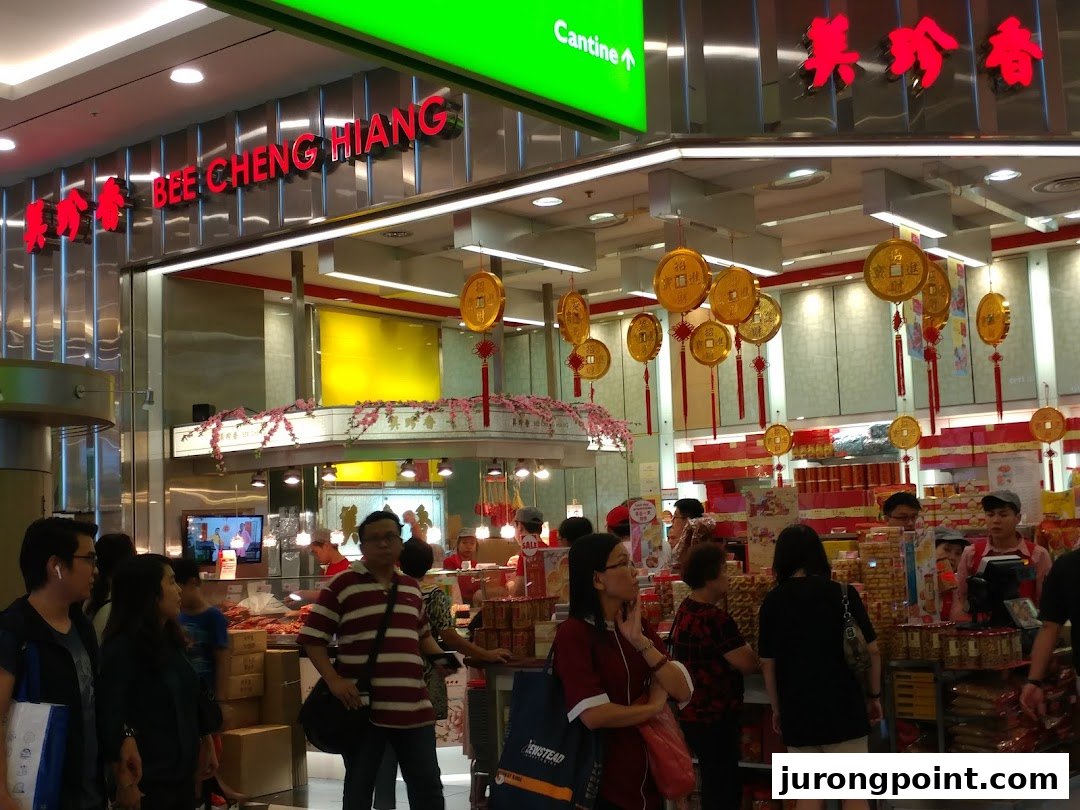 A bustling interior view of Bee Cheng Hiang, showcasing traditional snacks and customers browsing products.