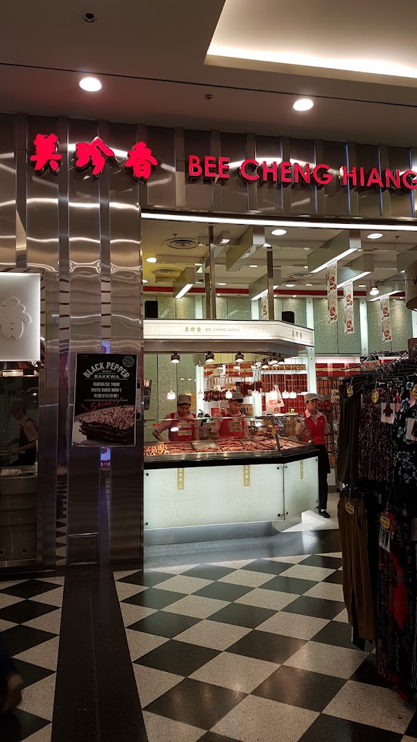Interior view of Bee Cheng Hiang shop, showcasing staff, product displays, and a Black Pepper Bakkwa promotion.
