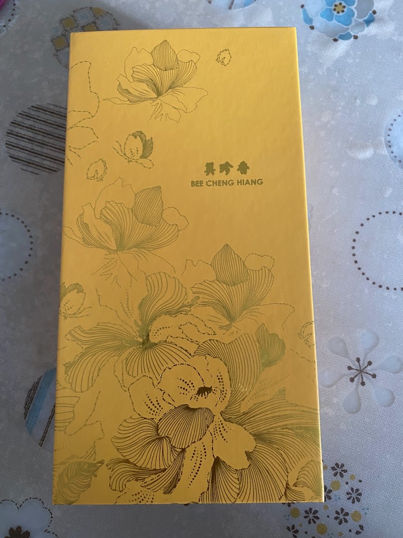 A premium yellow gift box from Bee Cheng Hiang featuring elegant floral designs.