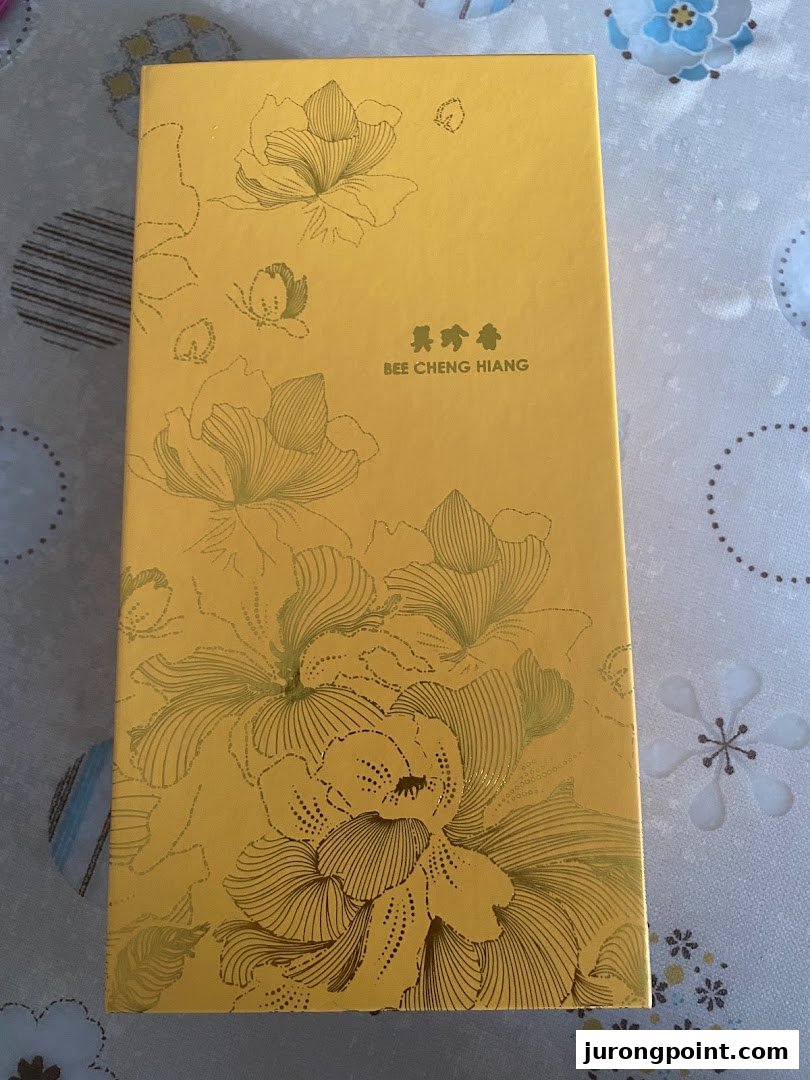 A premium yellow gift box from Bee Cheng Hiang featuring elegant floral designs.