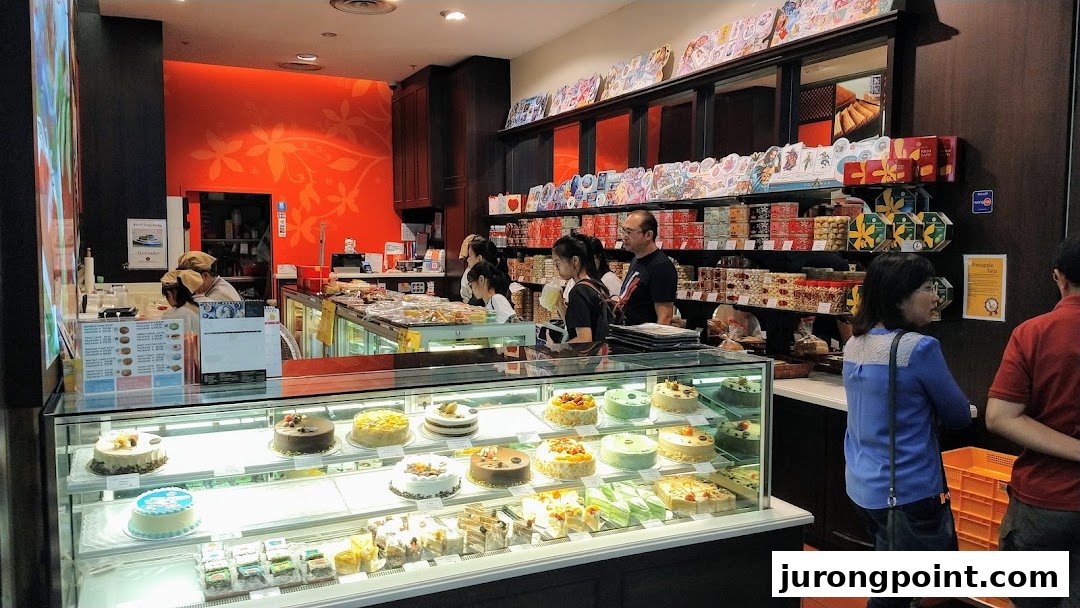 An interior view of Bengawan Solo bakery, showcasing a display of cakes, pastries, and customers.