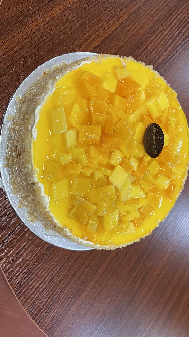 A vibrant mango cake from Bengawan Solo, topped with fresh mango chunks and a creamy base.