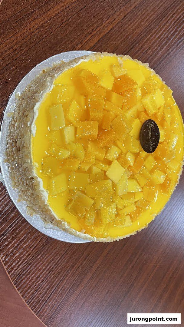A vibrant mango cake from Bengawan Solo, topped with fresh mango chunks and a creamy base.