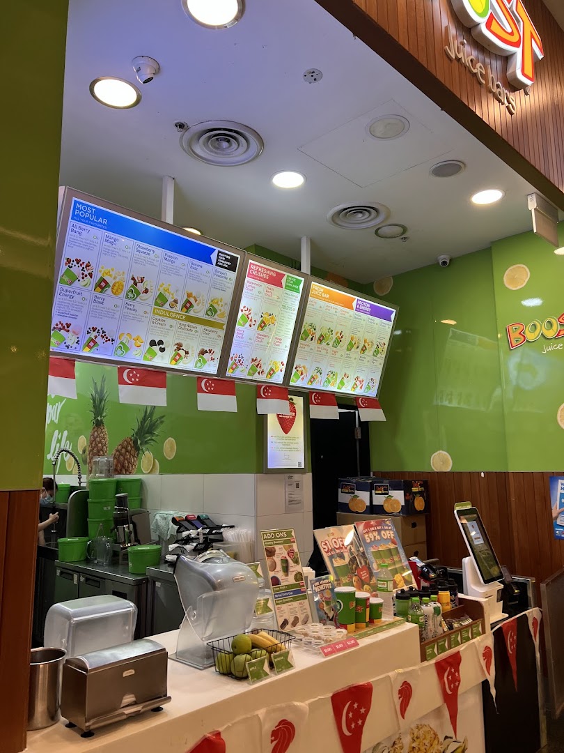 Interior view of Boost Juice featuring prominent digital menu boards displaying various juice and smoothie options.