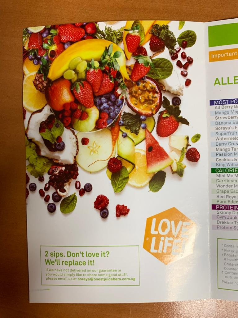 A vibrant menu page from Boost Juice featuring fresh fruits and a partial list of popular and healthy juice options.