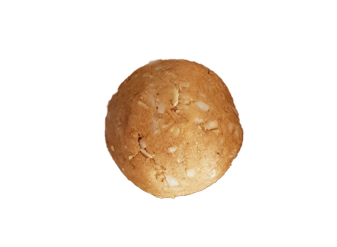 A close-up of a single, round, light brown energy ball with visible white specks.