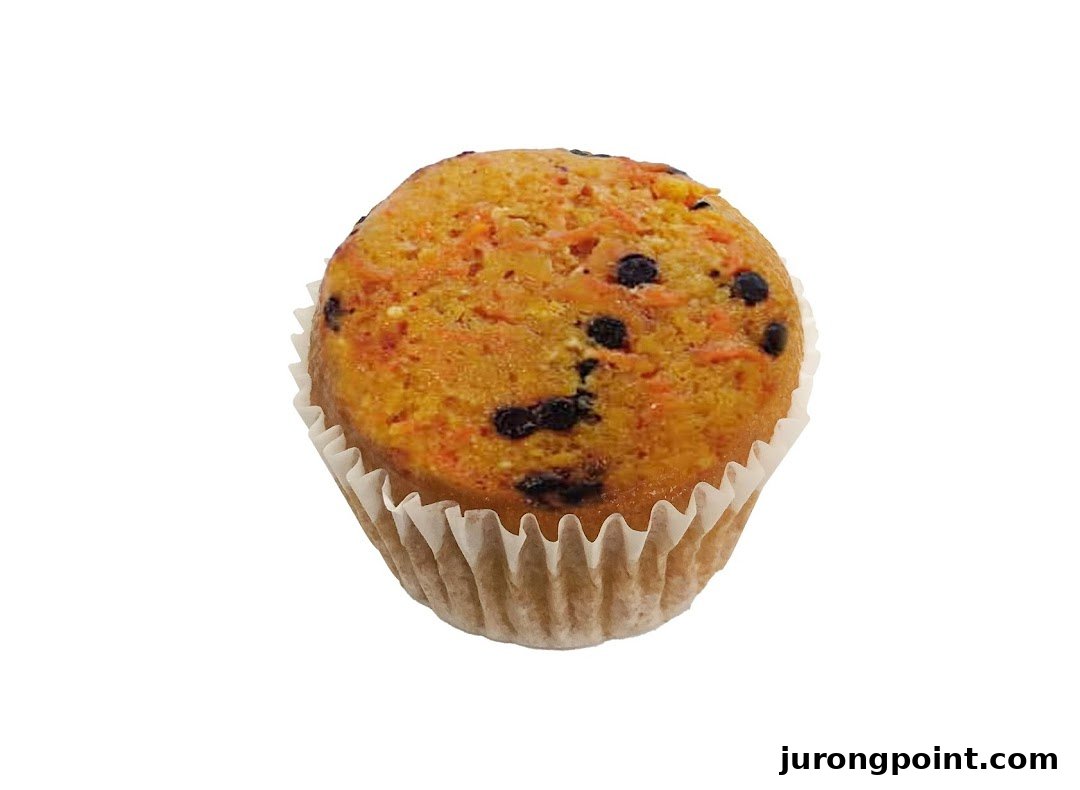 A delicious carrot muffin with chocolate chips in a white paper liner.