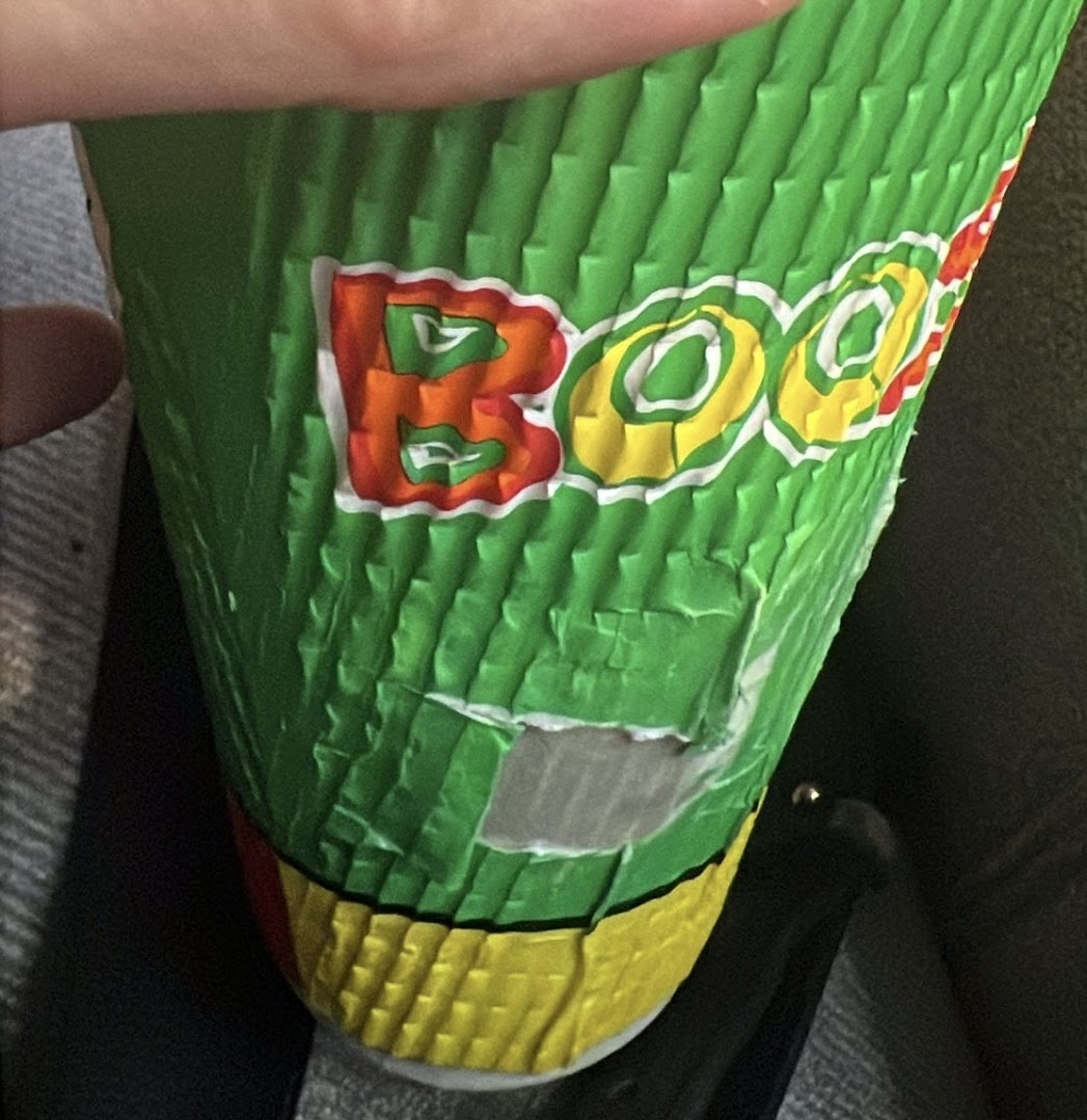 A close-up shot of a vibrant green Boost Juice cup featuring the brand's distinctive logo.