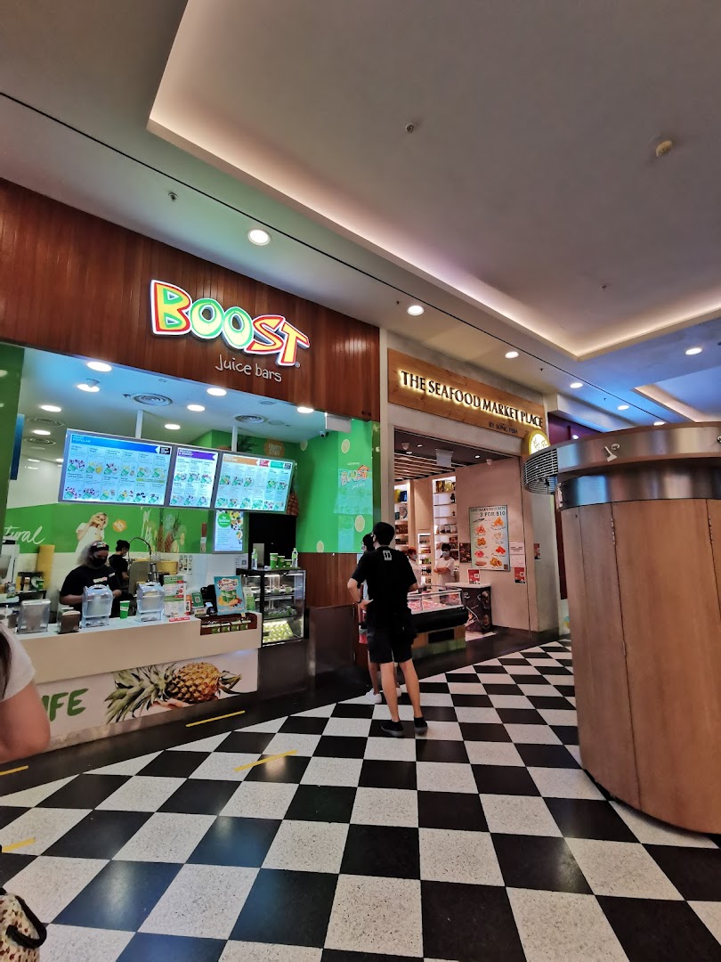 The vibrant Boost Juice bar entrance with its colorful logo and a distinctive checkered floor.