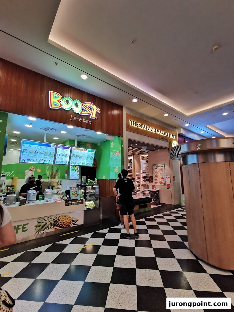 The vibrant Boost Juice bar entrance with its colorful logo and a distinctive checkered floor.