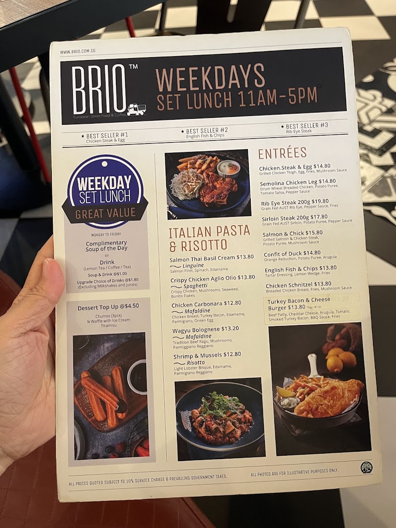 A hand holds a Brio restaurant menu displaying weekday set lunch options, Italian pasta, risotto, and entrées.