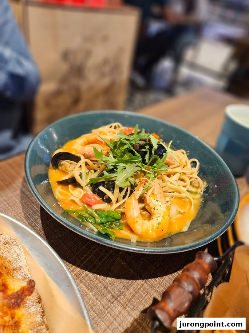 A vibrant bowl of seafood pasta with shrimp, mussels, and arugula on a wooden table.