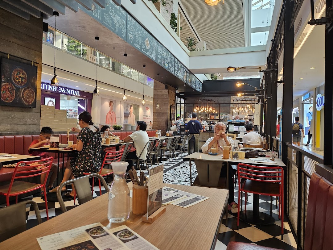 A bustling interior view of Brio restaurant with customers dining and a glimpse of the mall.