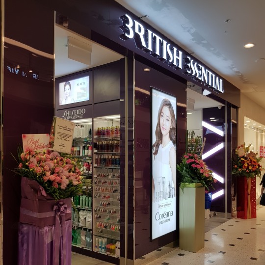 The brightly lit shopfront of British Essential, featuring beauty product displays and floral arrangements.