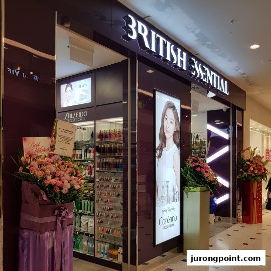 The brightly lit shopfront of British Essential, featuring beauty product displays and floral arrangements.