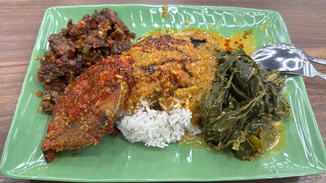 A vibrant plate of rice with various Asian dishes, including spicy fish, beef rendang, and green vegetables.