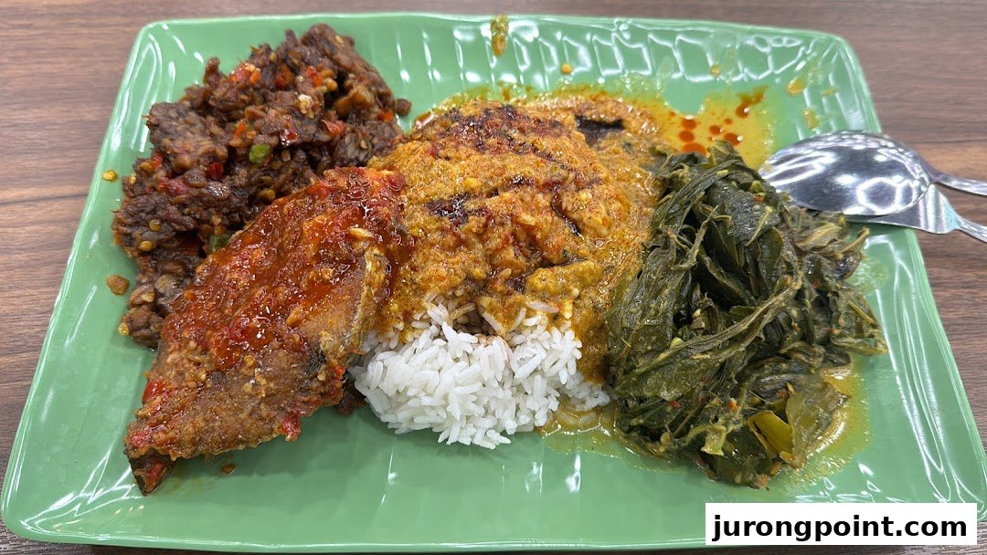 A vibrant plate of rice with various Asian dishes, including spicy fish, beef rendang, and green vegetables.
