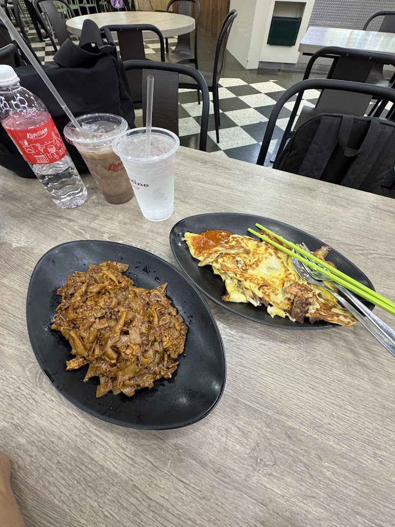 Two plates of local dishes and drinks on a table in a casual dining setting.