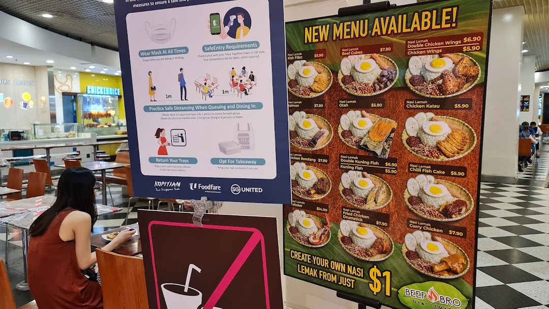 A large menu board showcasing various Nasi Lemak dishes and prices at Cantine by Kopitiam.