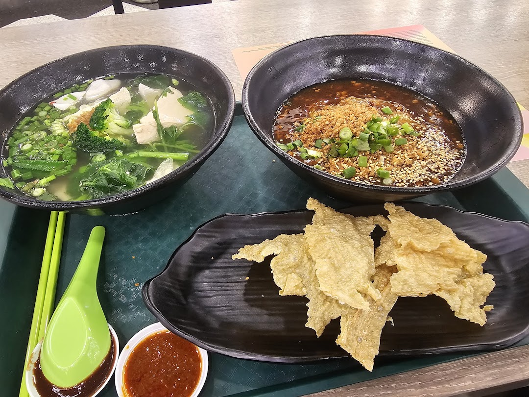 Two delicious Asian noodle/soup bowls with crispy fried wonton skins and dipping sauces on a tray.