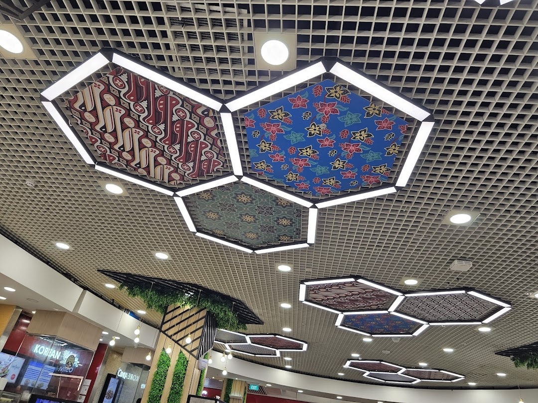 Decorative hexagonal ceiling lights with traditional patterns illuminate a modern food court area.
