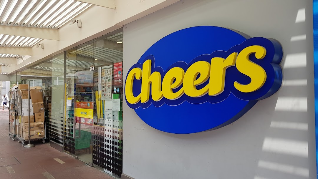 The exterior of a Cheers convenience store featuring its prominent blue and yellow logo and glass entrance.