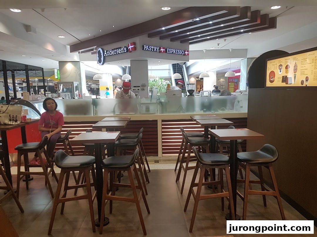 Interior view of Andersen's cafe featuring a prominent menu board, counter, and seating area.