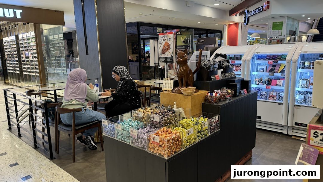 Customers enjoy treats at Chocolate Origin, featuring chocolate displays and a cozy seating area.