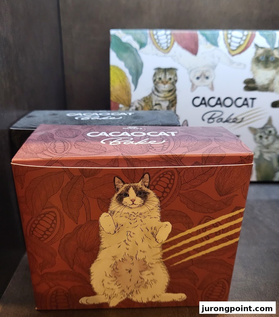 Close-up of CACAOCAT Bake chocolate boxes featuring charming cat illustrations, displayed on a shelf.