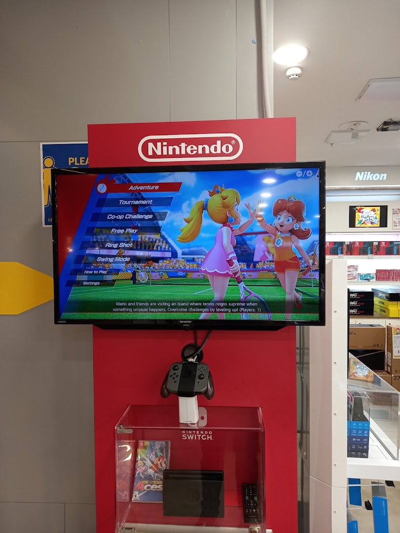 A Nintendo Switch demo station with a game playing on screen and a controller available for trial.