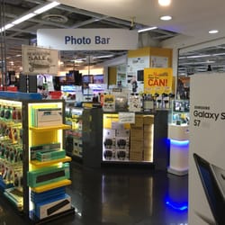 Interior view of COURTS electronics store featuring a 'Photo Bar' and various tech products.