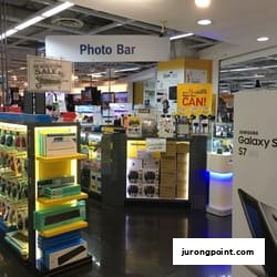 Interior view of COURTS electronics store featuring a 'Photo Bar' and various tech products.