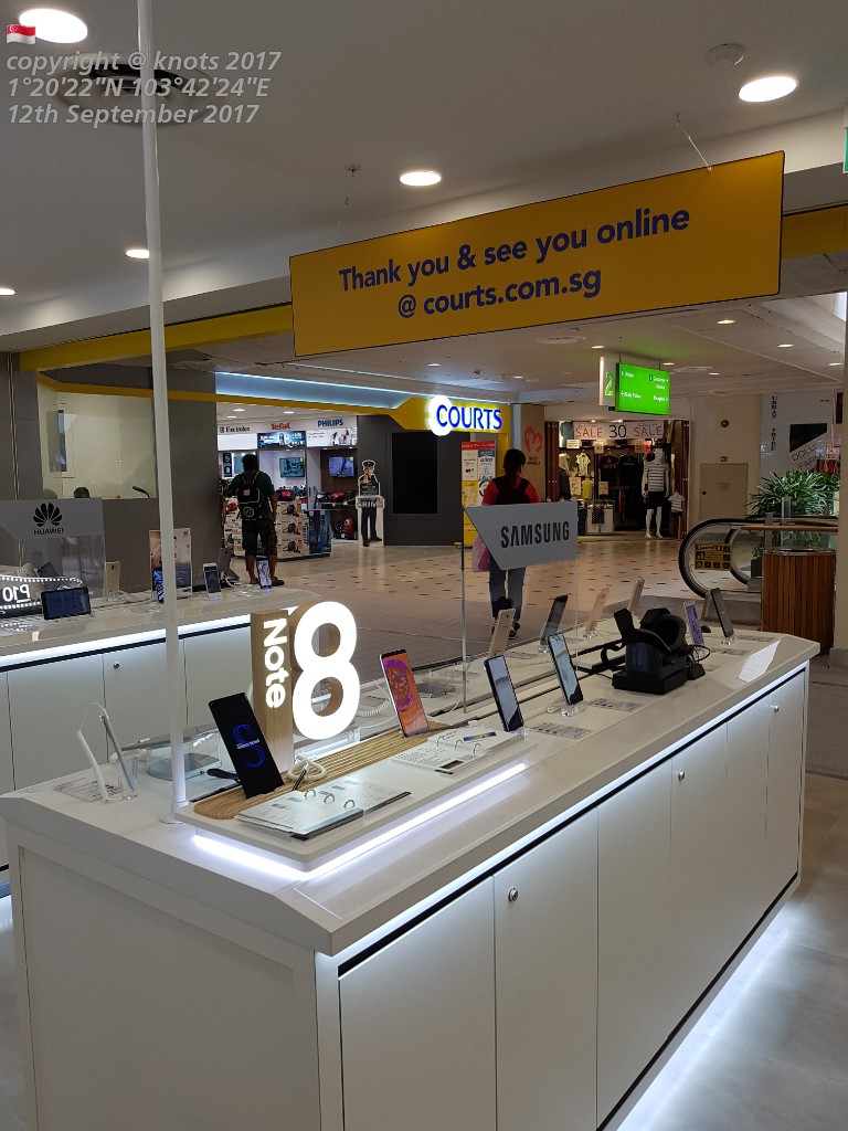 An in-store display of Samsung Note 8 phones at COURTS, featuring a prominent online presence sign.