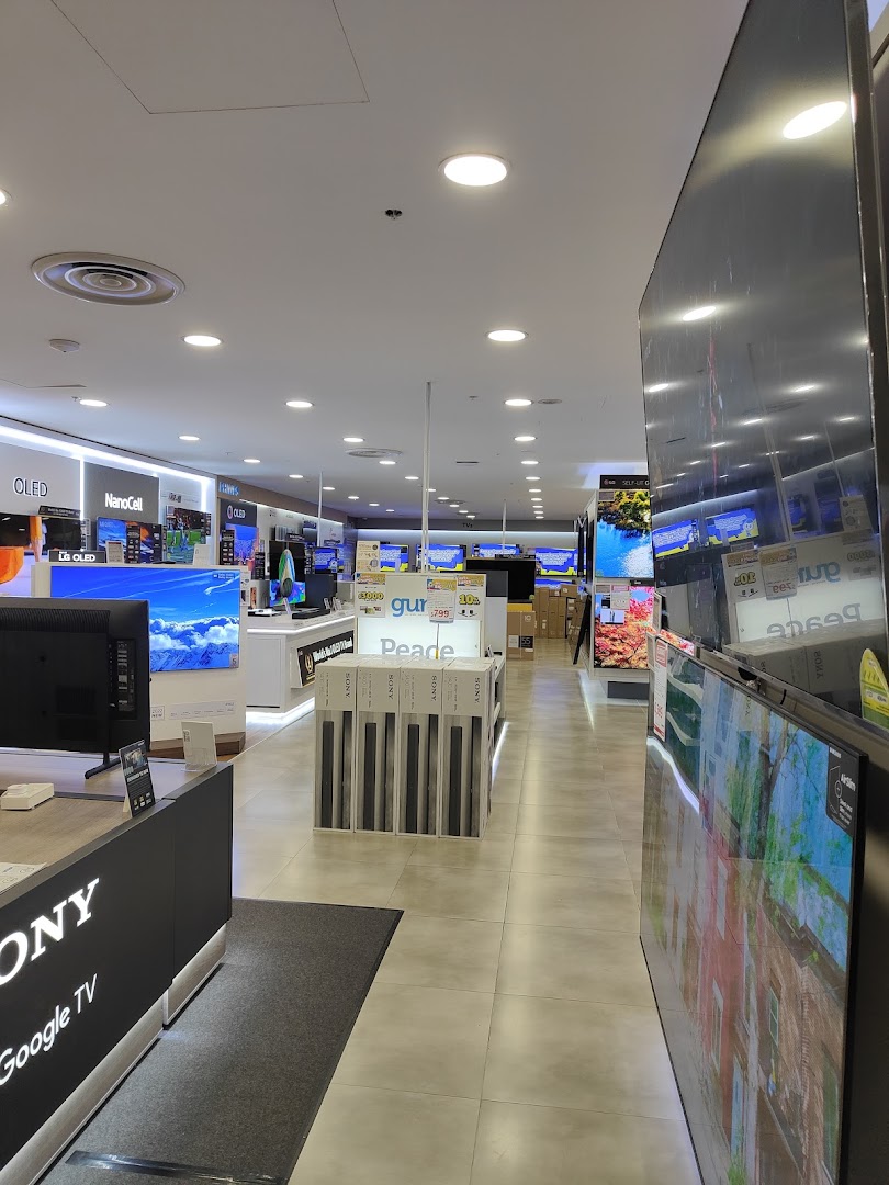 An interior view of COURTS electronics store, showcasing a wide array of televisions and home entertainment systems.