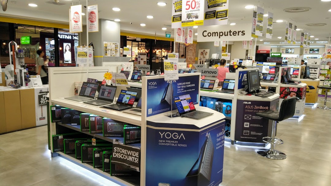 An electronics store interior showcasing various laptops, computers, and tech accessories on display.