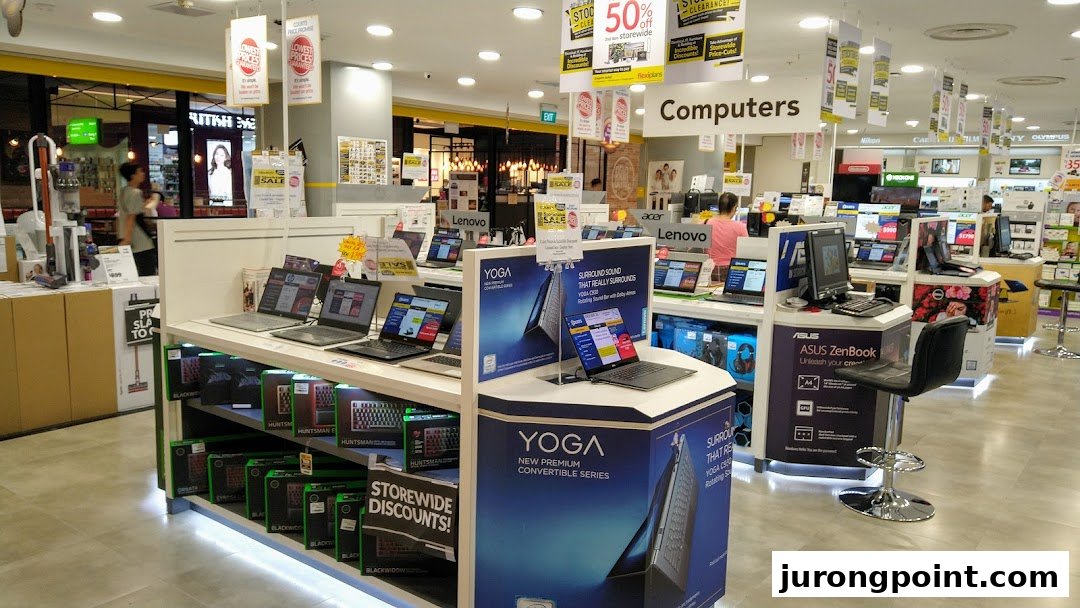 An electronics store interior showcasing various laptops, computers, and tech accessories on display.