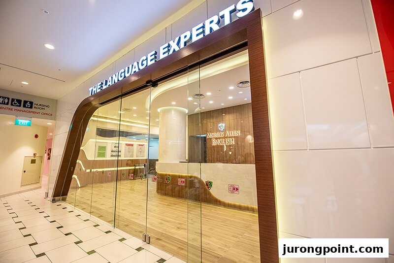 A modern glass-fronted entrance of an education centre with 'THE LANGUAGE EXPERTS' signage.
