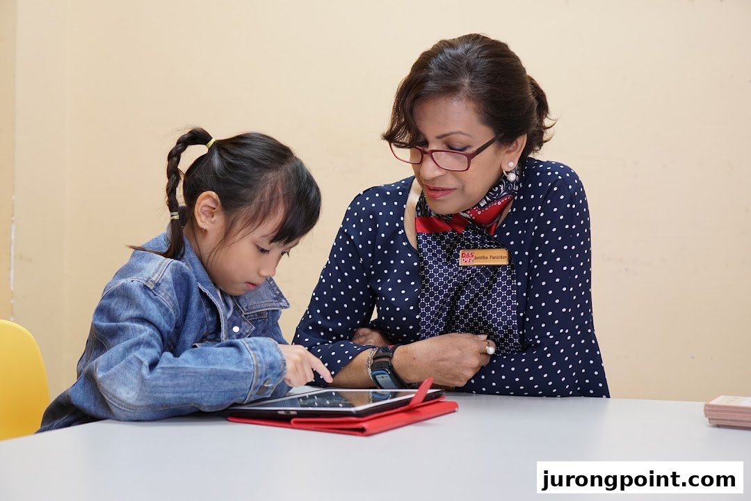 An adult instructor guides a child using a tablet at DAS International.