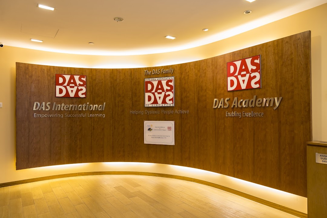 An interior view of DAS International's reception area, featuring a curved wooden wall with brand logos and mission statements.