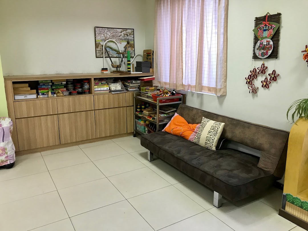 A cozy room interior with a sofa, wooden cabinet, and various decorative items, suggesting a comfortable community space.