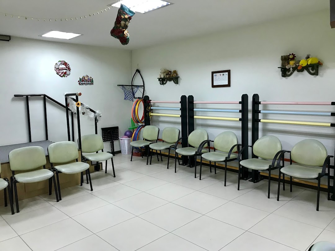An interior view of a therapy or activity room with chairs, rehabilitation equipment, and festive decorations.