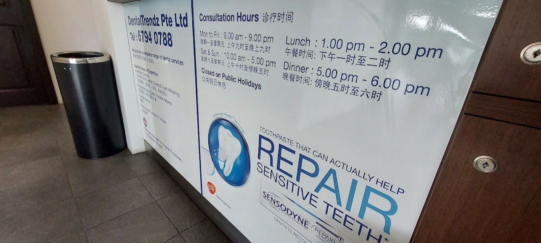 A sign displaying DentalTrendz's consultation hours, contact information, and a Sensodyne advertisement.