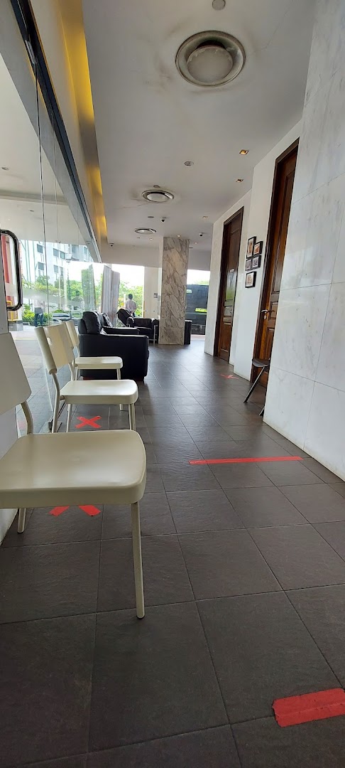 A bright, spacious waiting area with chairs and a sofa, featuring social distancing markers on the floor.