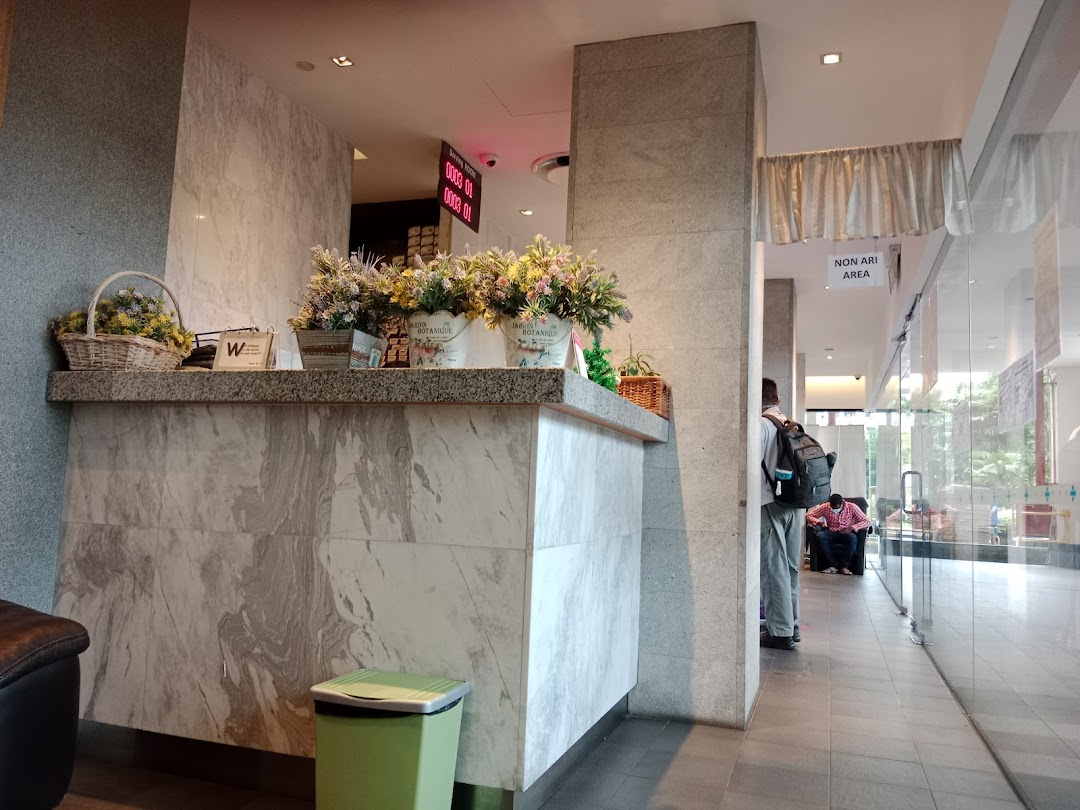 A well-lit reception area featuring a marble-patterned desk adorned with floral arrangements.