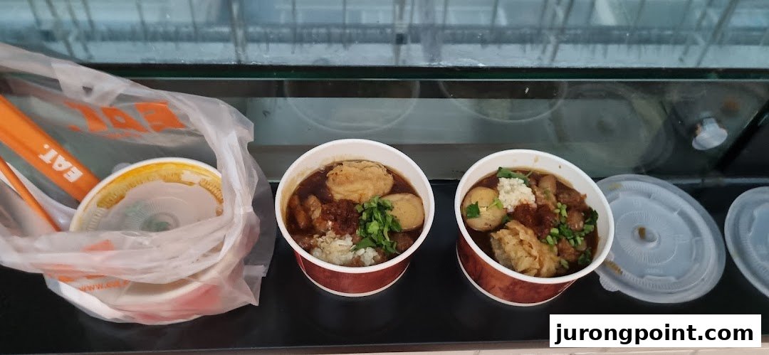 Two bowls of delicious-looking food, possibly noodles or stew, from EAT. ready for takeaway.